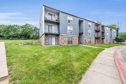 Apartment building with a green lawn in front.