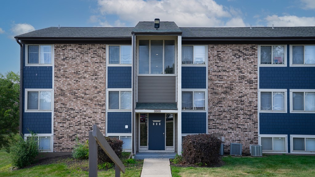A brick building with a blue door and windows.