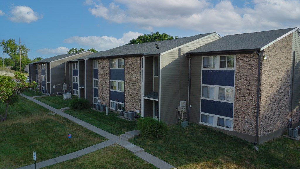 Apartment complex with a grassy area in front.