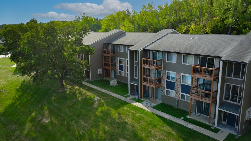 A row of modern townhouses with balconies and trees in the background.