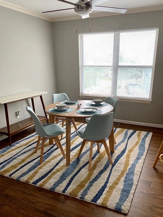 a dining room with a table and chairs on a rug