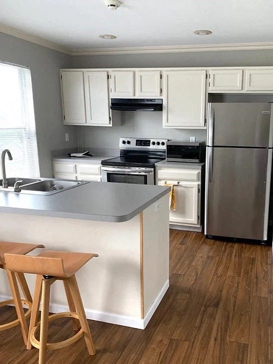 a kitchen with white cabinets and stainless steel appliances
