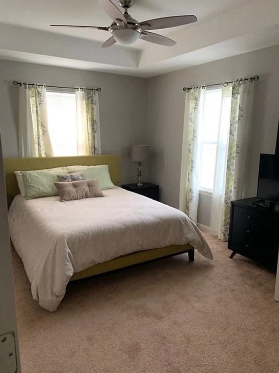 a bedroom with a bed and a ceiling fan