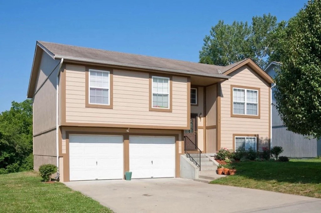 a tan house with a white garage door