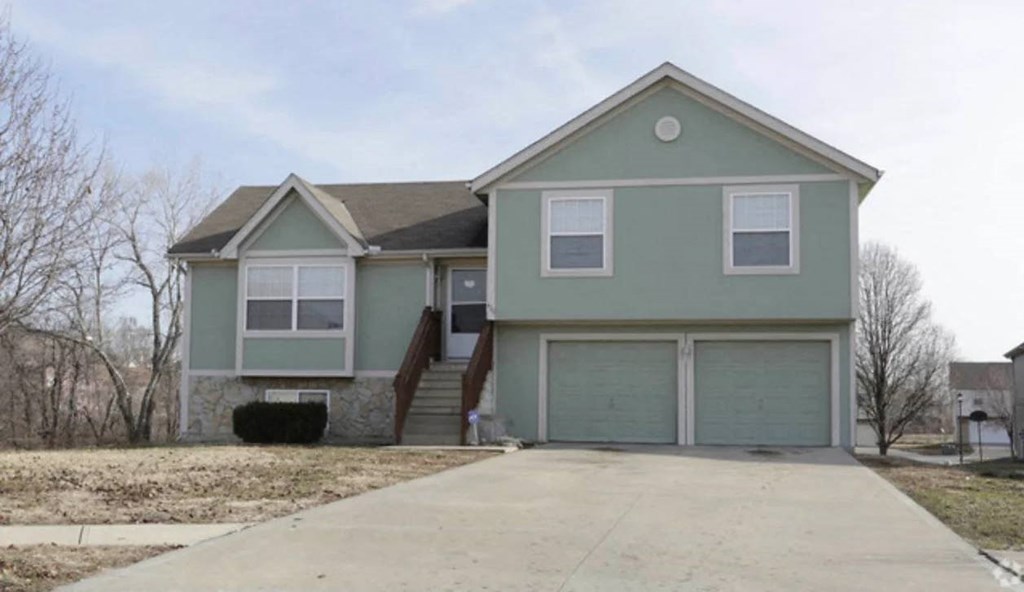 the front of a house with a driveway and a garage door