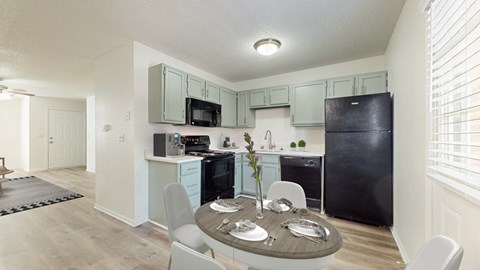 A kitchen with a table set for four.