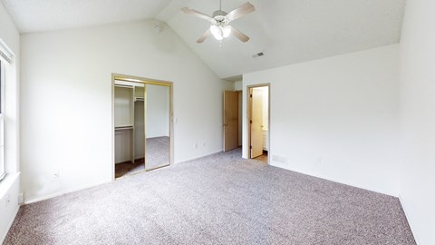 an empty living room with white walls and a ceiling fan