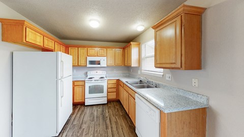 a kitchen with white appliances and wooden cabinets