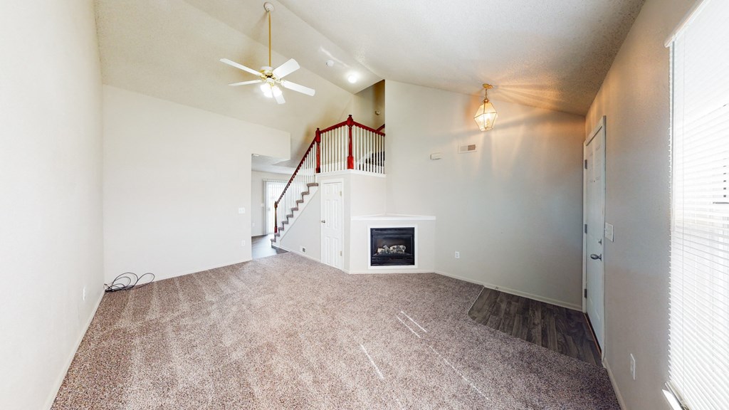 the living room and entryway of a house with white walls and a carpet floor