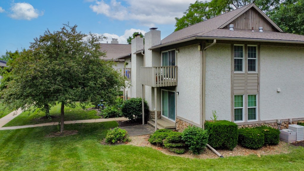 a home with a yard and a tree in front of it