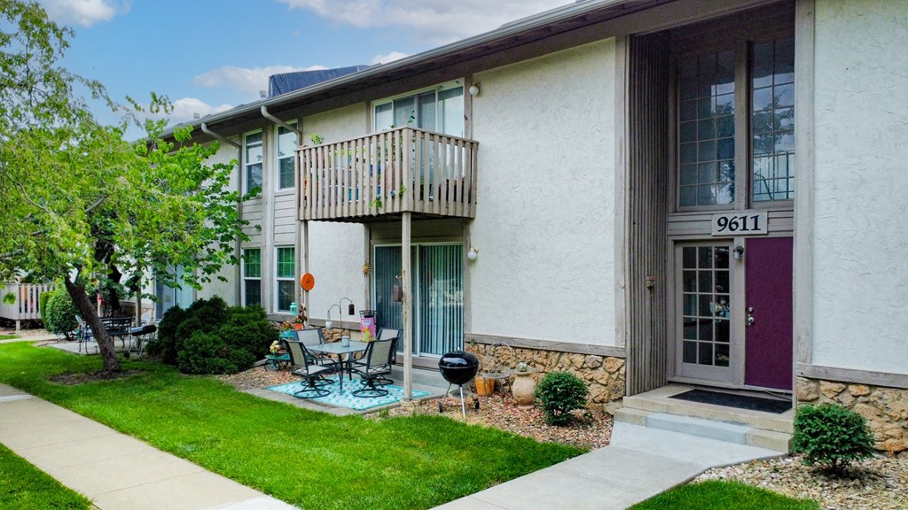 a patio in front of a building with a table and chairs
