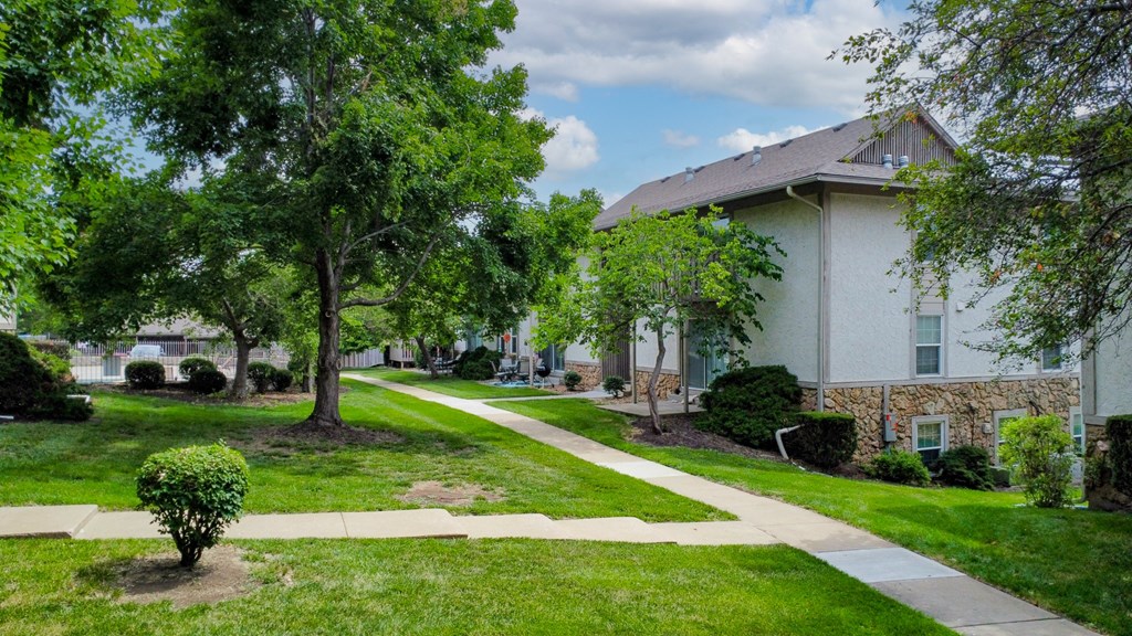 a house with a sidewalk and trees in front of it