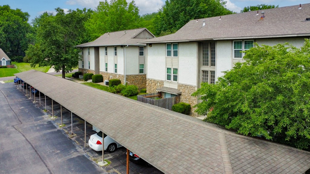 an overhead view of a white building with a parking lot