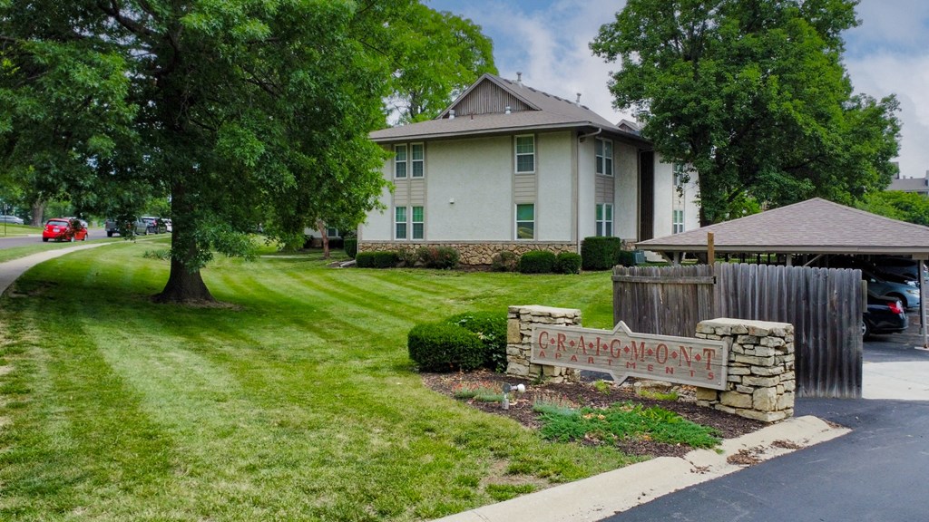 a house with a yard and a sign in front of it