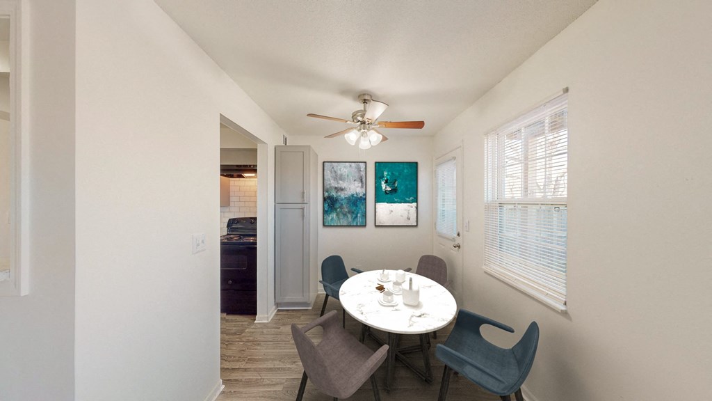 a dining room with a table and chairs and a ceiling fan
