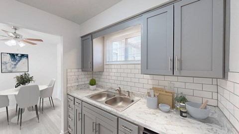 an open kitchen and dining room with a table and a sink