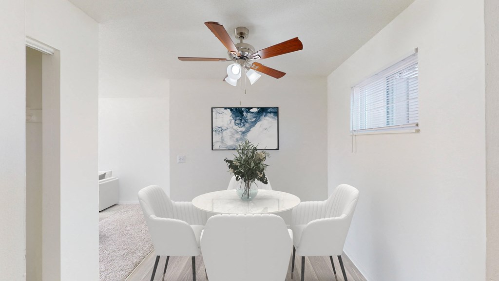 a dining room with a table and chairs and a ceiling fan