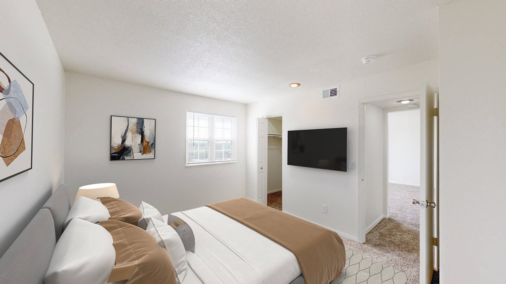 a bedroom with a bed and a tv on the wall
