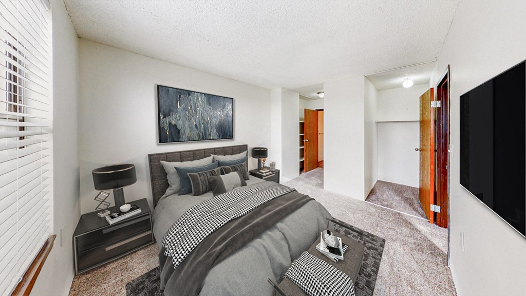 a master bedroom with a large bed and a tv