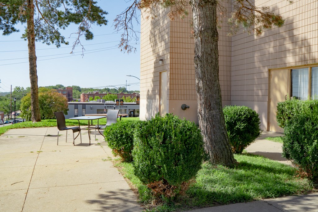 a patio with a table and chairs in front of a building