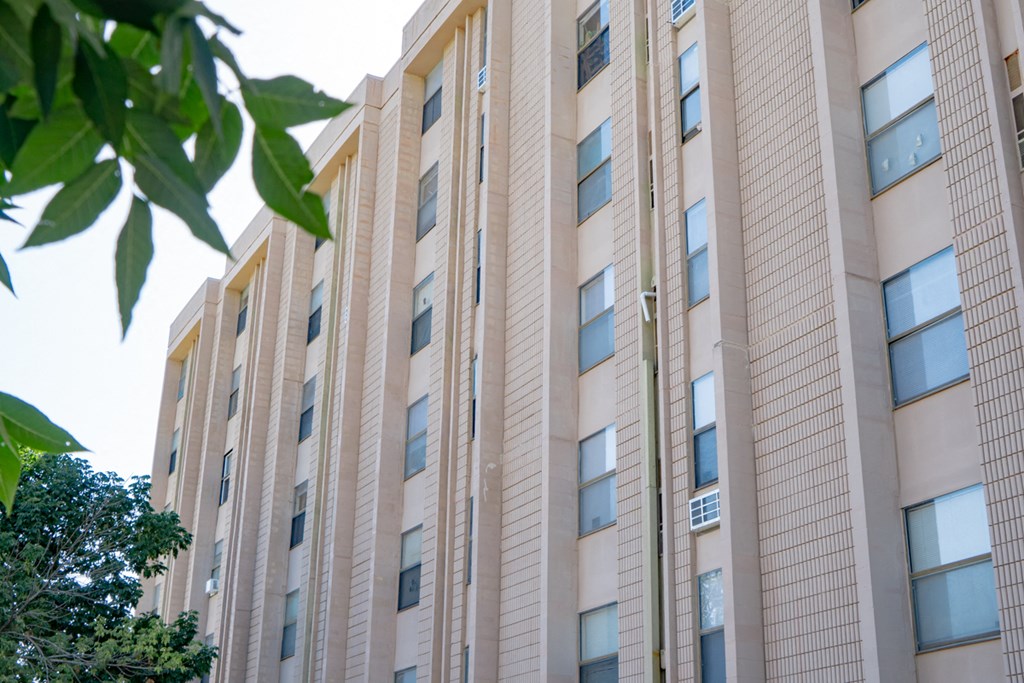 a large building with many windows and a tree in front