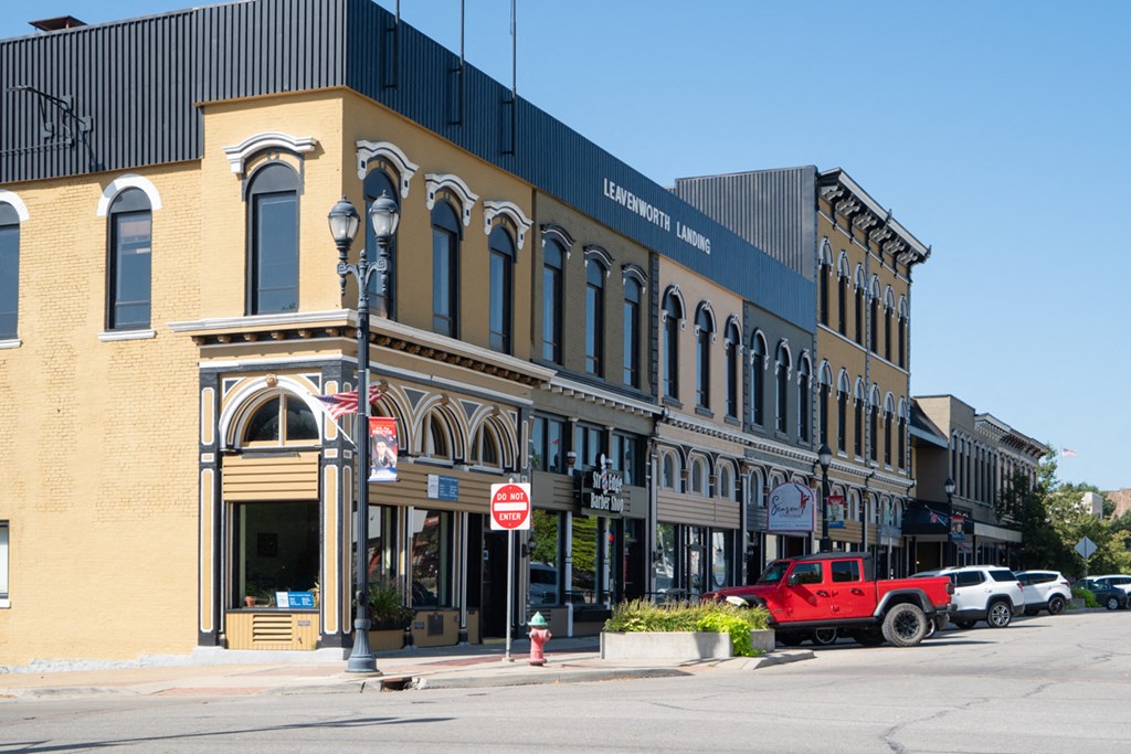 a building on the corner of a street with a red truck