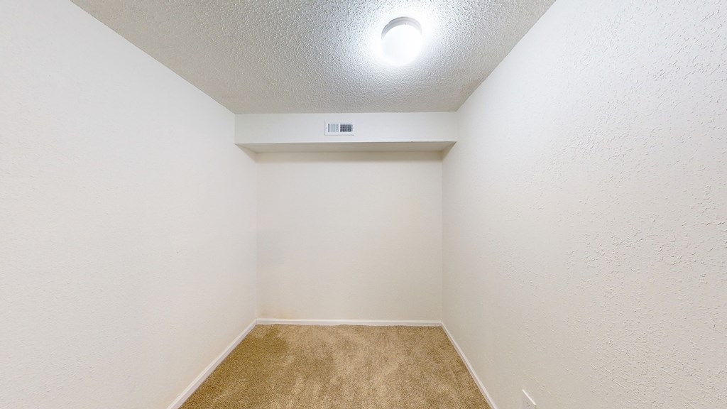 an empty room with white walls and a carpet