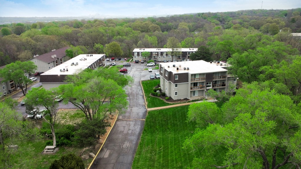 an aerial view of a neighborhood of apartment buildings and green trees