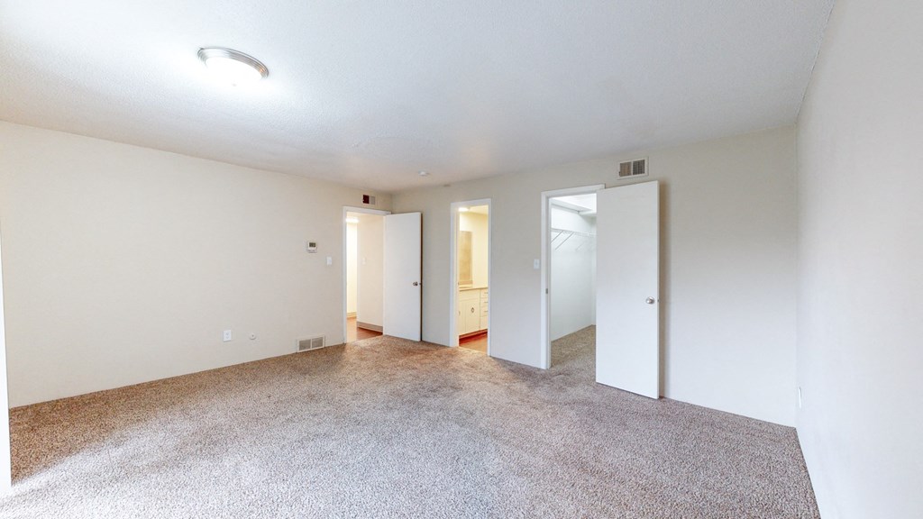 an empty living room with white walls and a carpeted floor