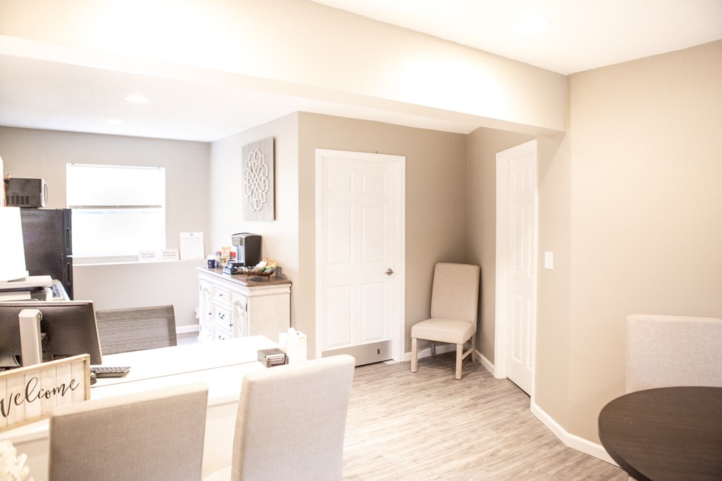 a living room and dining room with a desk and a chair