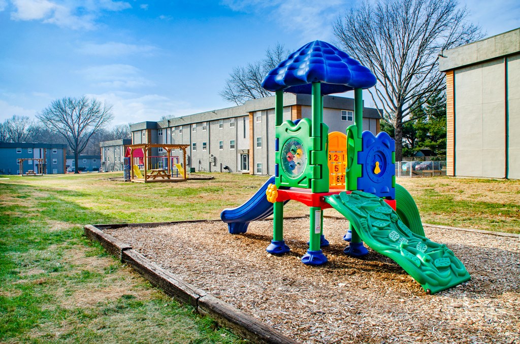 a playground at a school with a blue and green play structure