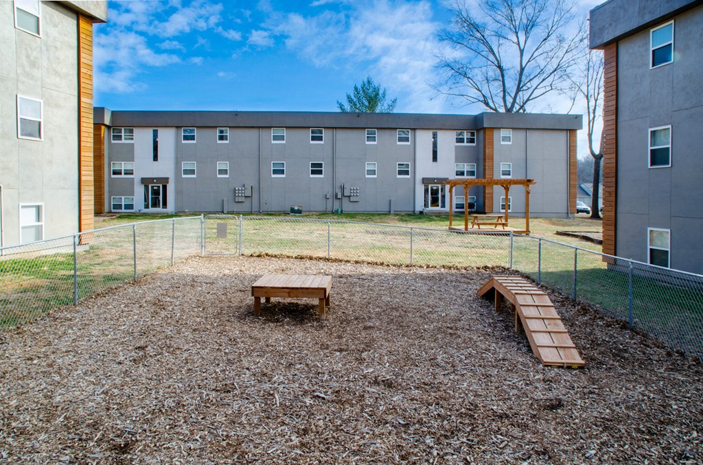 a fenced in play area in front of a building