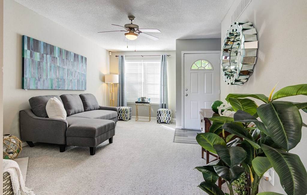 a living room with a couch and a ceiling fan