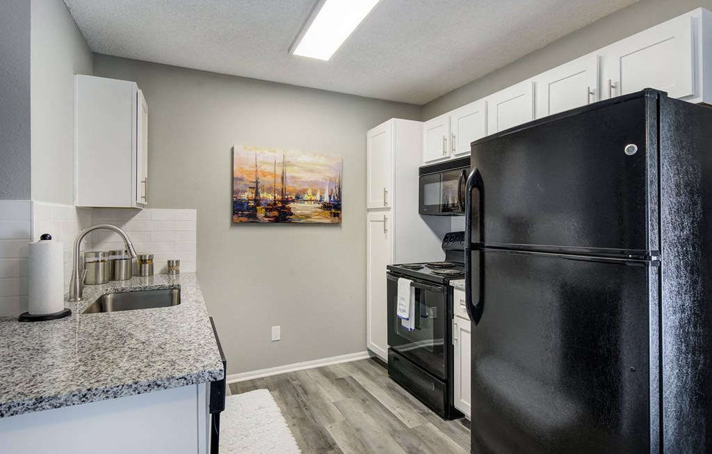 a kitchen with black appliances and granite counter tops
