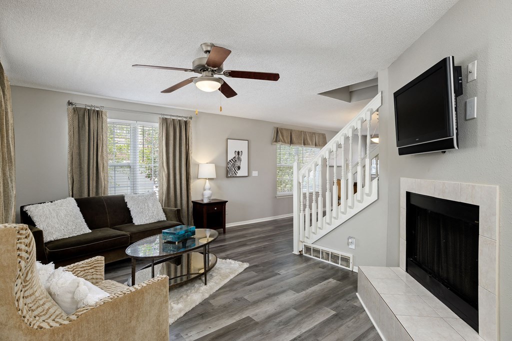 a living room with a couch and a tv and a staircase