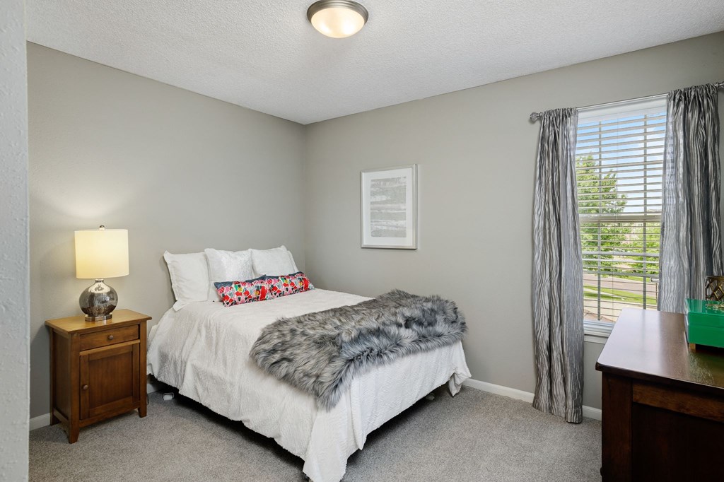 the master bedroom has a comfy bed and a window