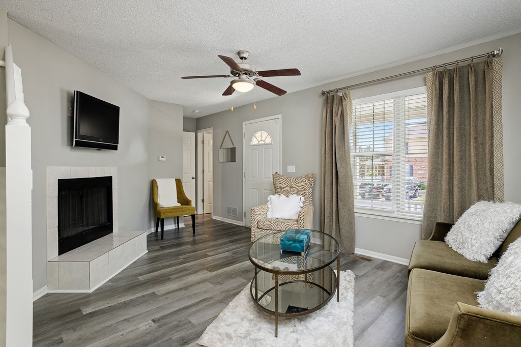 a living room with a fireplace and a ceiling fan