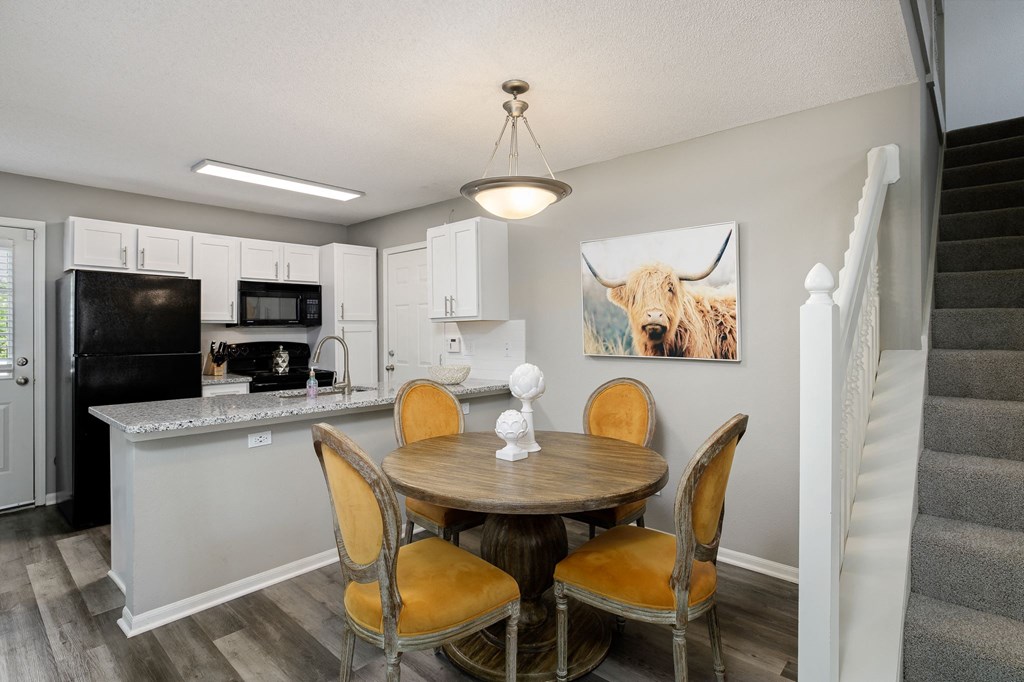 a dining room with a table and chairs next to a kitchen