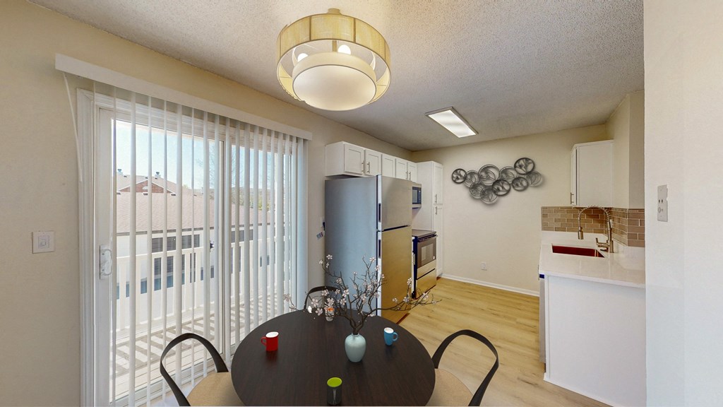a dining room with a table and chairs and a kitchen with a refrigerator