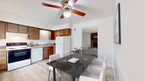 a kitchen and dining room with white appliances and a black dining table