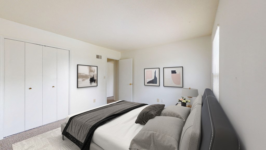a bedroom with white walls and a bed pillows