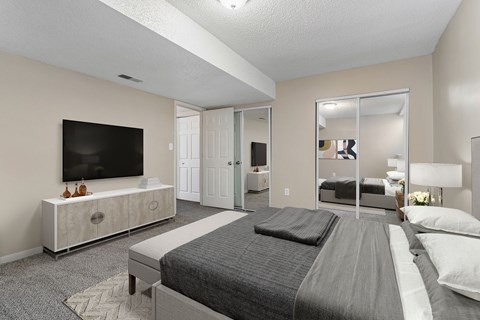 A bedroom with a large bed and a television on a cabinet.