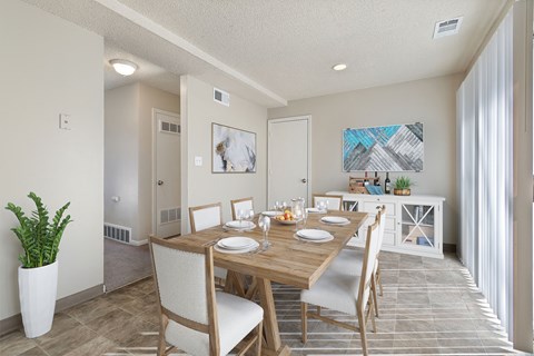 A dining room with a wooden table set for two.
