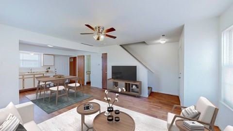 A living room with a white ceiling fan and a wooden coffee table.