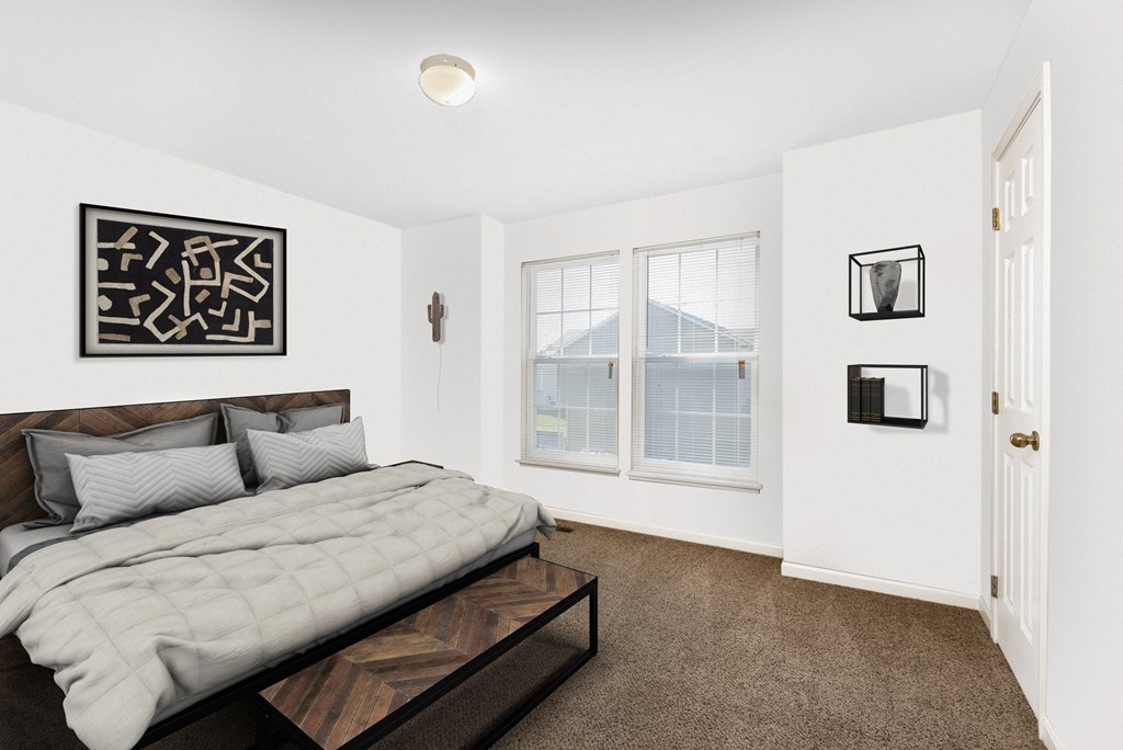 A bedroom with a large bed and a picture on the wall.