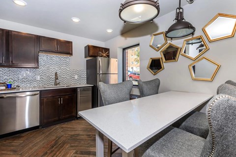 A kitchen with a table and chairs and a refrigerator.