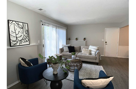 A living room with a blue chair and a white couch.