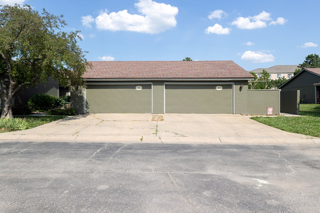 A large garage with a grey roof and tan walls.