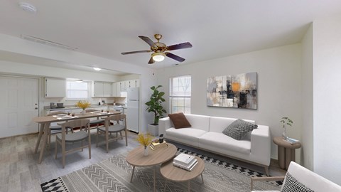 A living room with a white couch, a coffee table, and a ceiling fan.