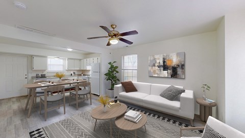 A living room with a white couch, a dining table, and a ceiling fan.